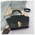 Black crocodile embossed leather crossbody bag with gold chain and handle in a flat lay setup - Black