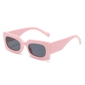 Retro square sunglasses with thick pink frame and dark lenses shown from a 45-degree angle - Pink Frame Grey Lens