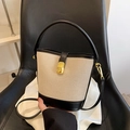 Secchiello in tela beige con finiture in pelle nera e fibbia dorata su sedia - Nero