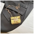 Mini gold crocodile embossed crossbody bag with metallic chain on a grey blazer - Gold