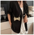 Chic gold bow-shaped mini crossbody bag with sleek chain strap shown on a model - Gold