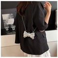 Détail d'un sac bandoulière argenté en forme de nœud avec chaîne métallique - Argenté