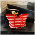Macro detail of red and white striped woven tote bag with durable leather handles - Red