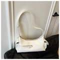 Detail view of white gloss shoulder bag featuring side pockets and a front decorative zipper - White