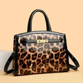 Glossy leopard print crossbody handbag with metallic gold twist lock and black handles - Leopard Print