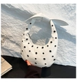 Detail of white glossy leather underarm bag with silver metal eyelets and knotted strap - White