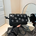 Chic black patent leather crossbody bag with silver grommet accents and a flap closure - Black