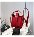 Détail du sac seau en cuir verni rouge avec rivets argentés et boucle métallique décorative - Rouge