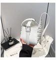 Détail du sac à main blanc orné de rivets argentés et d'une boucle au design moderne - Blanc