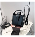 Détail du sac seau en cuir verni noir avec clous argentés et boucle de ceinture décorative - Noir
