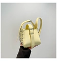 Détail du sac seau jaune clair avec rivets argentés et poignée à boucle métallique - Jaune