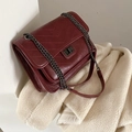 Borsa a tracolla trapuntata rosso scuro con cuciture a V e catena su sfondo di lana - Fucsia