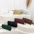 Woven baguette bags in seven colors with metal clasps on white display steps - Silver