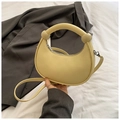 Detail of cream crescent bag with pebble leather texture and silver zipper hardware - Yellow