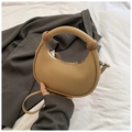 Detail of a beige half-moon handbag featuring thick handles and decorative round spheres - Khaki