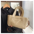 Close-up of beige woven tote bag with triangular pattern and brown shoulder strap - Off White