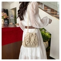 Modell mit einer cremefarbenen handgewebten Beuteltasche im Boho-Stil und Schultergurt - Khaki