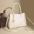 Borsa a mano bianca in pelle martellata con pendente dorato e tracolla regolabile - Bianco Sporco