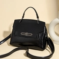 Detalle del bolso negro de cuero brillante arrugado con hebilla metálica plateada en el asa - Negro