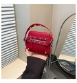 Gros plan d'un mini sac en cuir rouge avec rivets argentés et bandoulière en chaîne - Rouge