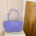 Sac fourre-tout tressé violet lavande avec longues anses posé sur une valise - Violet