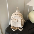Creamy white backpack with large bow detail and textured PU leather in a soft setting - White