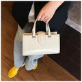 Detail view of cream polished leather handbag with silver hardware and top handles - White