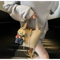 Détail du sac seau beige texture lychee avec fermoir métallique et breloque petit ours - Avec Pendentif / Kaki