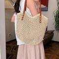 Borsa tote in paglia beige con spalline in pelle marrone indossata da una modella - Bianco Sporco