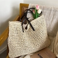 Schicke cremefarbene Strohtasche mit braunen Ledergriffen und Blumen im sommerlichen Stil - Gebrochenes Weiß