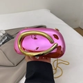 Close-up of rose pink metallic clutch with oval frame and golden curved hardware detail - Pink