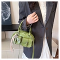 Dettaglio della borsa boston verde in ecopelle con doppie tasche frontali e ciondoli - Senza Ciondolo / Verde