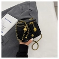 Quilted black bucket bag with gold chain strap and camellia charm shown by model - Black