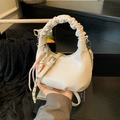 Off-white crossbody bag with pleated handle and heart charm in a lifestyle setting - No Pendant / White