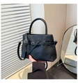 Detalle del bolso de mano negro en cuero granulado con hebilla decorativa y textura - Negro