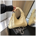 Detail of light yellow glossy leather tote bag with V-cut opening and silver metal accents - Yellow