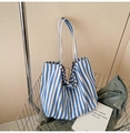 Blue and white striped canvas bucket bag with wide shoulder straps in a shopping basket - Narrow Stripe Sky Blue