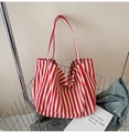 Red and white striped canvas bucket bag with shoulder strap in a stylish casual setting - Fine Red Stripe