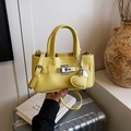 Bright yellow pebbled leather handbag with silver twist lock and heart charm accessory - Yellow