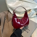 Minimalist red patent leather crescent bag with dual zippers and sleek metallic buckles - Red