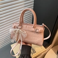 Bolso rosa con textura de cocodrilo, colgante de perlas y lazo de encaje - Rosa Con Colgante