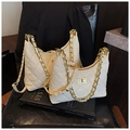 Sac hobo matelassé beige avec chaîne dorée posé sur un livre d'art sophistiqué - Petit / Blanc