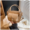 Beige lychee leather crossbody bag with metal buckle and detachable strap in hand - Yellow