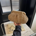 Sac nuage en paille tressée beige avec bandoulière chaîne dorée porté élégamment à la main - Khaki