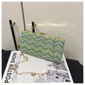 Detail der gewebten Clutch mit Wellenmuster, Goldrahmen und abnehmbarer Kettenriemen - Grün