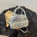 Borsa azzurra con fiocco, pizzo e nastro a quadretti su giacca di pelle nera - Blu