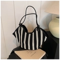 Dettaglio della borsa tote intrecciata a righe bianche e nere con manici in pelle - Stile a righe bianche e nere