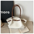 Detail of cream tote bag with litchi grain texture, brown handles and gold metal lock - White Brown