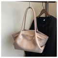 Detail of light beige lychee pattern leather tote bag with gold buckle on a coat rack - Khaki