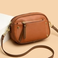 Brown lychee leather crossbody bag with white stitching and gold studs on beige background - Brown